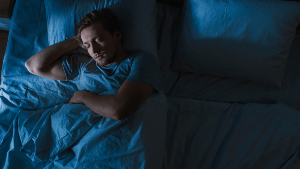 Image of person sleeping in a bed in a dark room